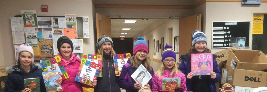Young children proudly brandish their newly obtained books for the camera to see.