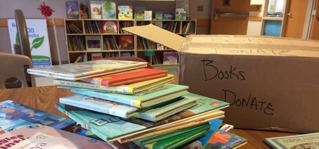 A stack of books sitting at a book donation.