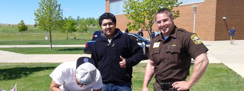 A group of men give the camera a thumbs-up at the career fair.