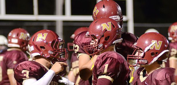 The Northfield High School football team celebrates on field after a successful play.